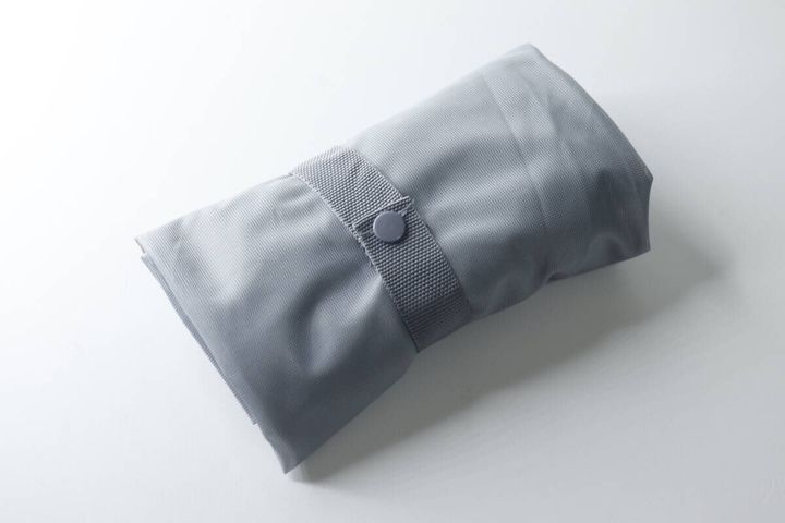 コンパクトに折りたたまれボタンで留められた洗濯バッグ