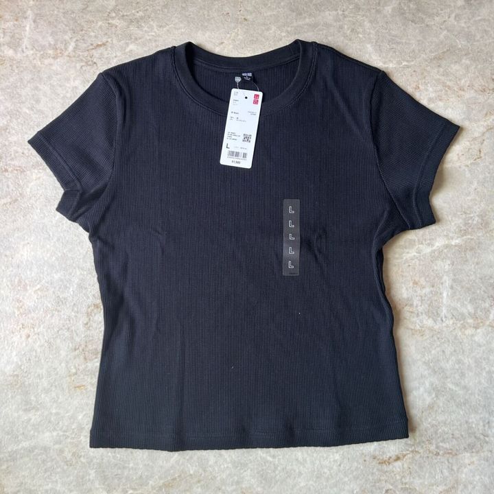 黒いリブミニTシャツが平置きされ、商品タグが付いている