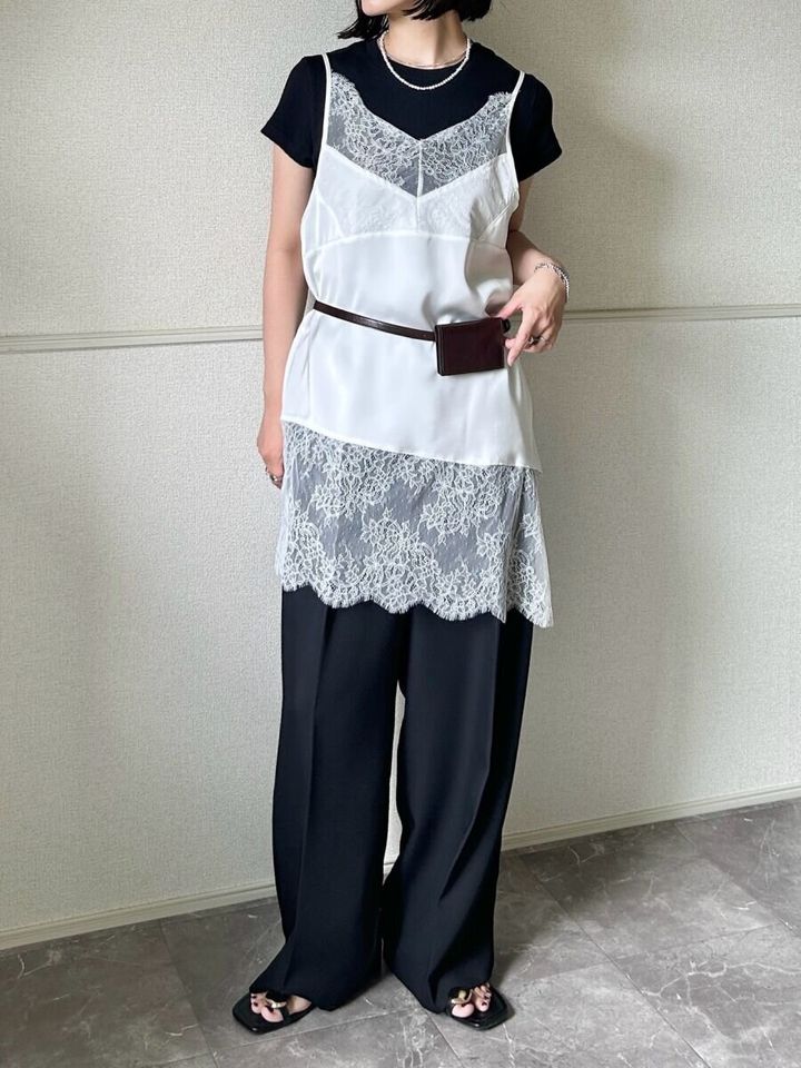 黒いリブミニTシャツの上に白いレースキャミソールを重ね着した女性の全身