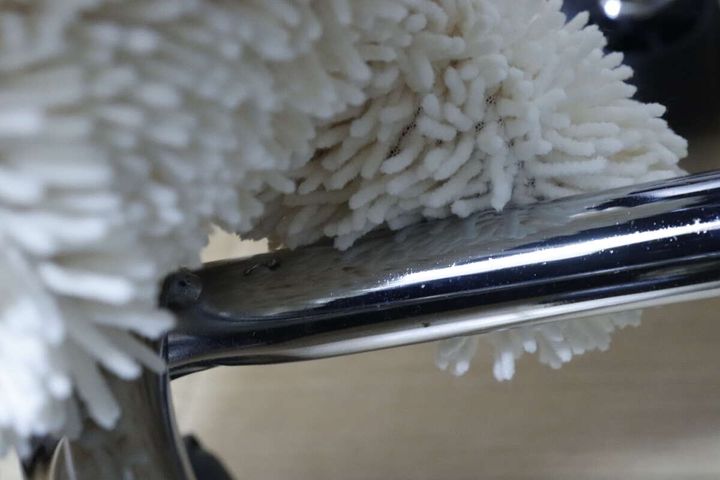 お掃除手袋で椅子の金属パイプ部分を拭いている