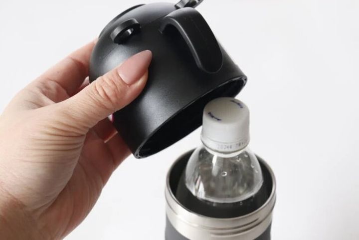 黒いペットボトルホルダーの蓋を女性が持ち上げ、中にペットボトルが入っている