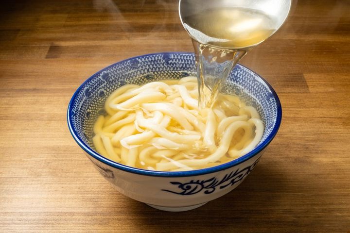 うどんに出汁をかける様子