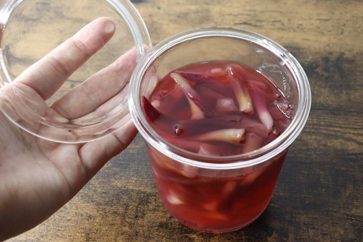茗荷の甘酢漬けが入った容器の蓋を開けている手元