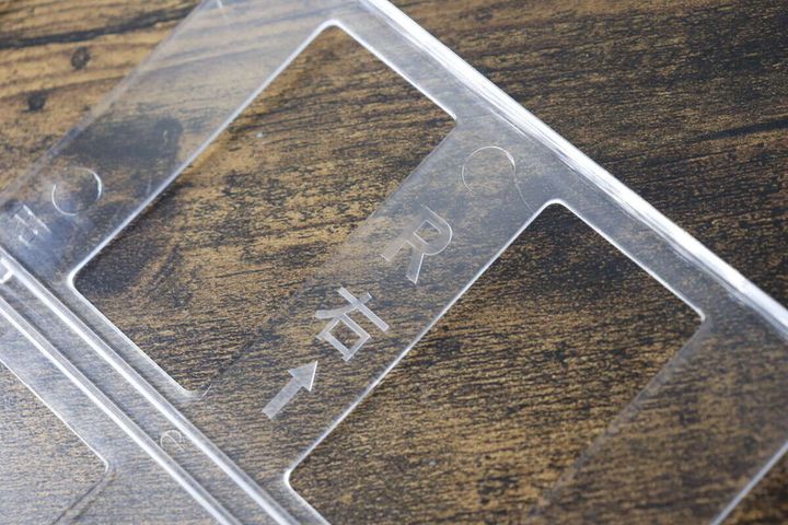 缶ボトルホルダーの透明な板に印字された「→右」の文字