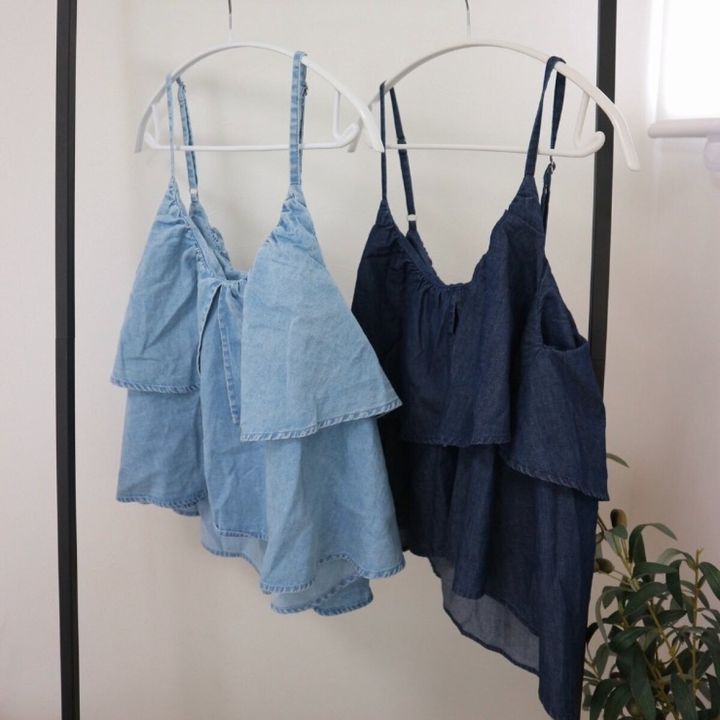 明るい青と濃い青のフリル付きデニムビスチェがハンガーにかけられている
