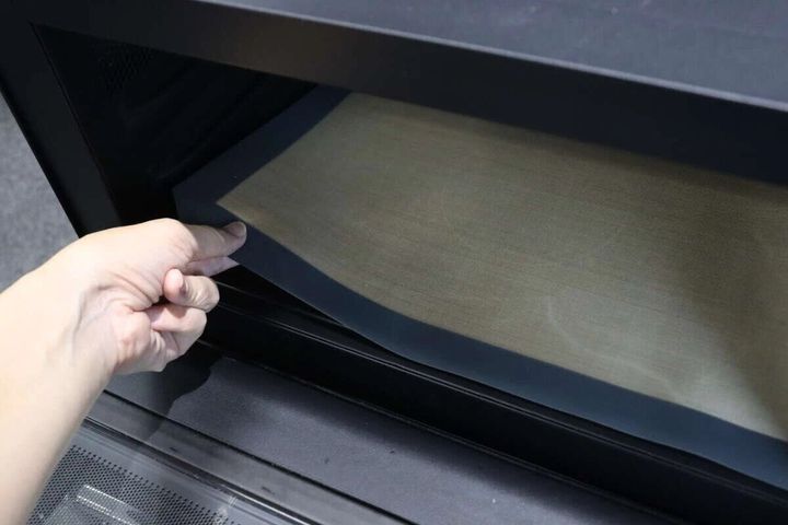 電子レンジ庫内にシリコーンマットを敷く様子