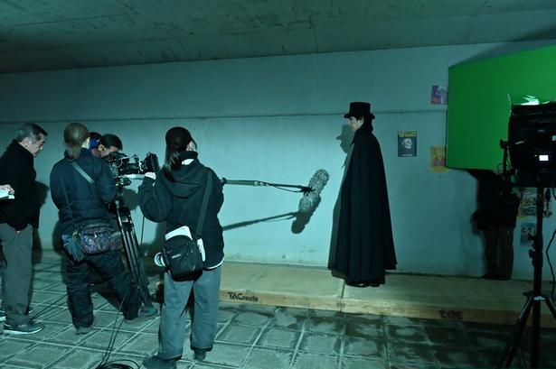 【写真を見る】青木涼演じる怪しげな黒マントの男！グリーンバックで撮影中 [c]2026 IRH Press