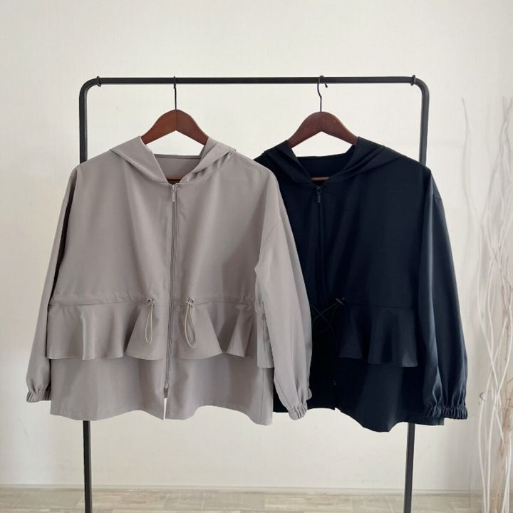 裾フリル付きのグレーと黒のラッシュパーカーがハンガーラックに並ぶ