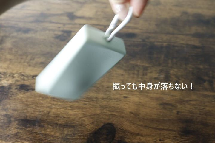 中身が入ったケースを振っても落ちないことを示す手元