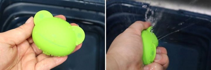 緑色の動物型水風船を握り、水を出している手のアップ