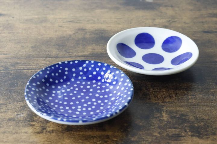 青い水玉模様と白い水玉模様の豆皿が木製のテーブルに並べられている
