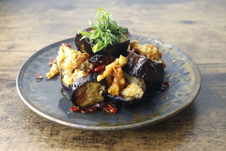 鶏皮とナスを調理し大葉を添えた一品料理の盛り付け
