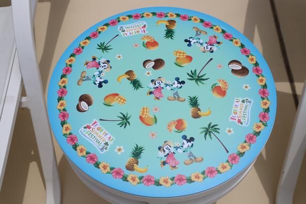 テーブルのデザインもトロピカル！ミッキーとミニー、ヤシの木やフルーツなどのモチーフを、ハイビスカスがぐるりと囲む