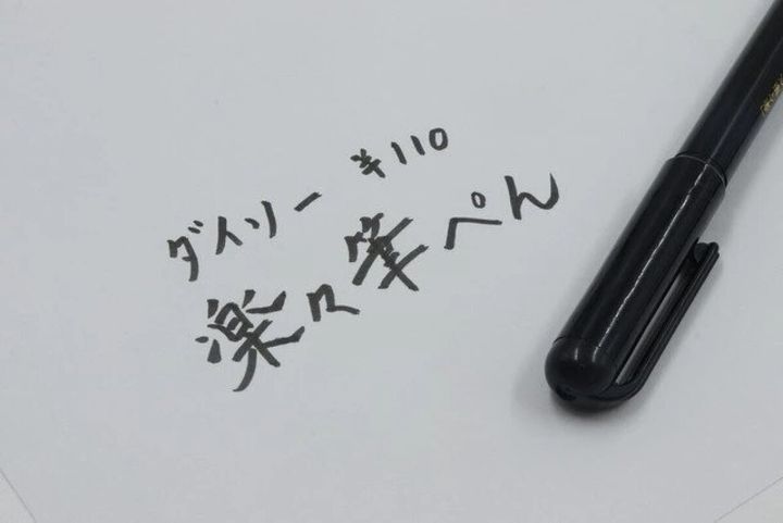 白い紙に書かれた「ダイソー 楽々筆ぺん」の文字と筆ペン