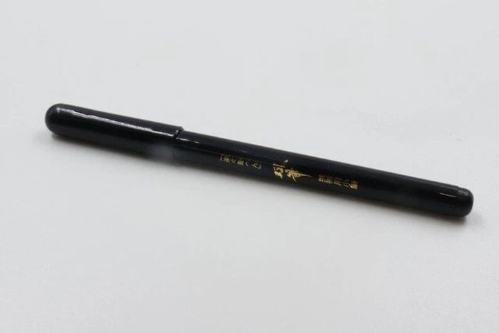黒い筆ペン「双筆双雲モデル」が白い背景に置かれている