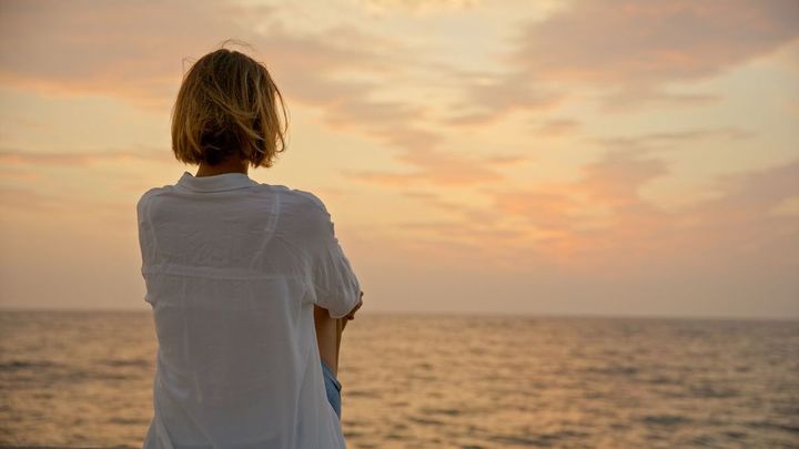 海を見つめている女性の後ろ姿