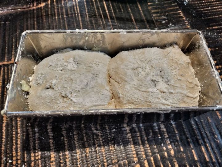 10、手順8の生地を半分に切り、2つに分ける→それぞれ、両端を折りたたみ、クルッと丸める→手順9の型に入れる→オーブンで二次発酵させる（40分程）