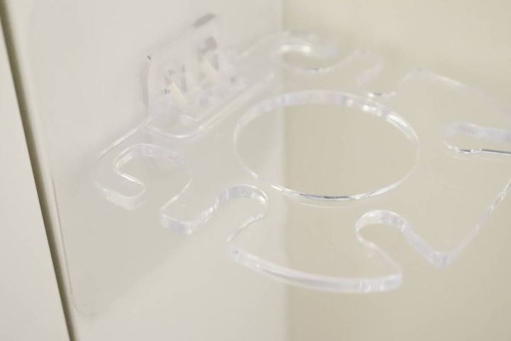 壁に貼り付けられた透明な歯ブラシホルダーのアップ