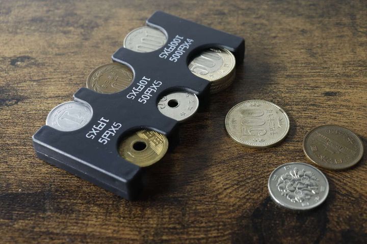 コインホルダーに硬貨が収納され、周りに数枚の硬貨が散らばっている俯瞰写真