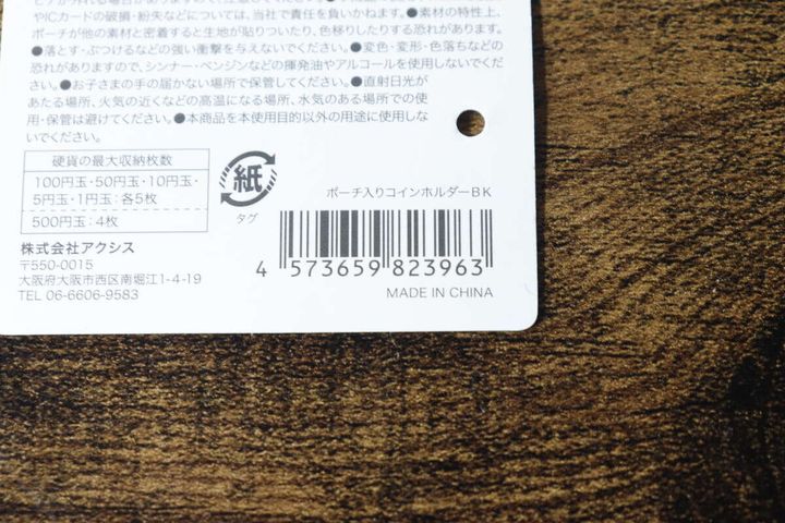ポーチ入りコインホルダーの商品タグ裏面、バーコードと商品情報が記載されている