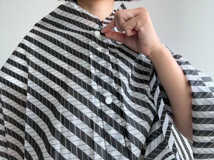 レインケープの首元のスナップボタンを留める女性