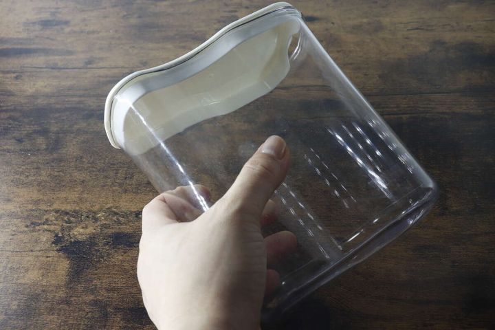 透明なピッチャーのくびれ部分を片手で掴んでいる様子
