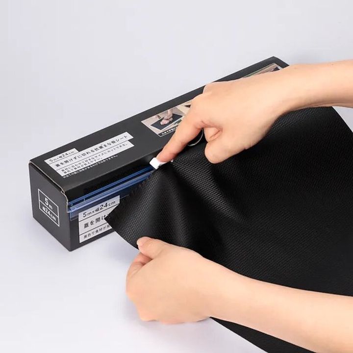 黒いまな板シートを箱から引き出す手元