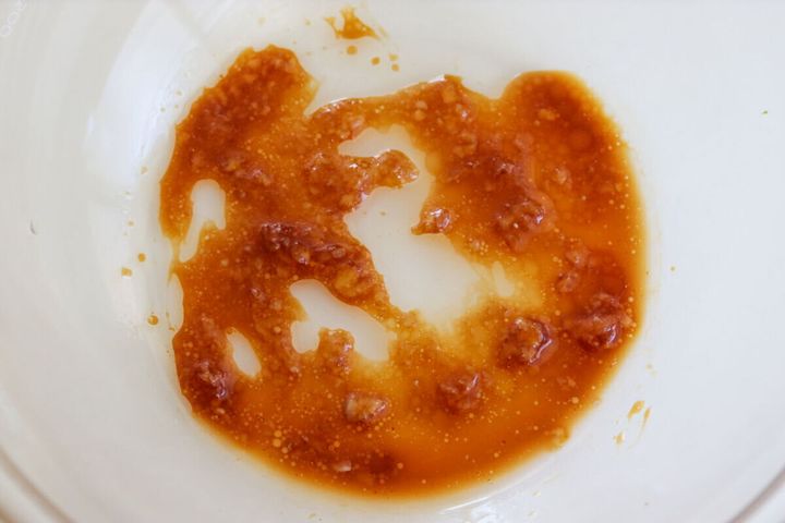 透明なボウルに、しょうゆ、砂糖、にんにく、ごま油を混ぜ合わせたタレが入っている様子