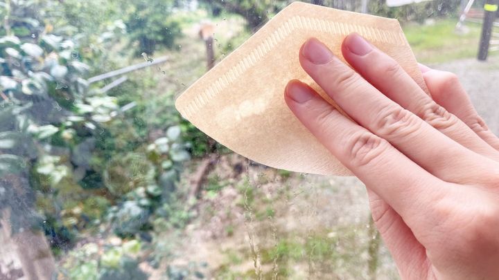 コーヒーフィルターで窓ガラスを拭いている様子