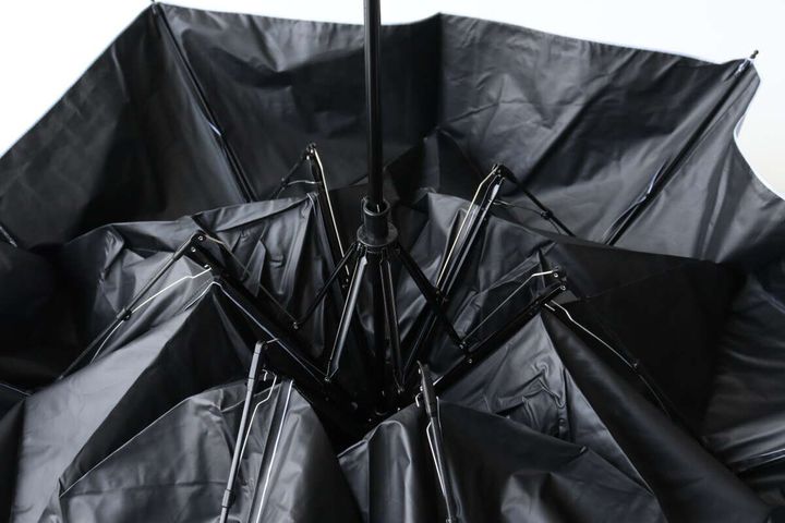 開いた傘の内側から見た黒い生地と骨組みの様子