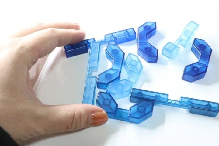 手が青い立体知育パズルを分解する様子