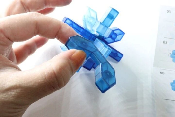 手が青い立体知育パズルを組み立てる様子