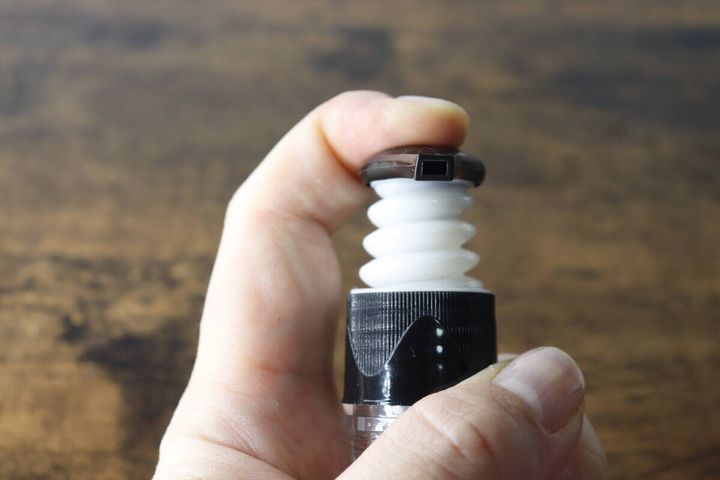 ポンプヘッドの蛇腹状の可動部を指で押している様子