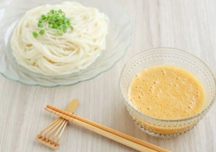 そうめんが盛られた皿と、納豆卵だれが入った器、箸