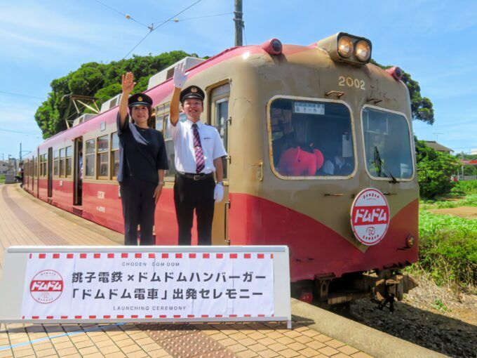 犬吠駅で「ドムドム電車」に出発の合図を送る銚子電鉄 西上社長（右）ドムドムフードサービスの藤﨑社長