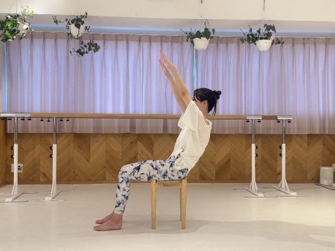 息を吸いながら両手を頬骨の延長線の高さまで伸ばす。
