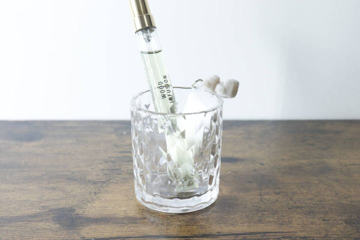 ミニグラスにアロマディフューザーのボトルとスティックを入れた様子