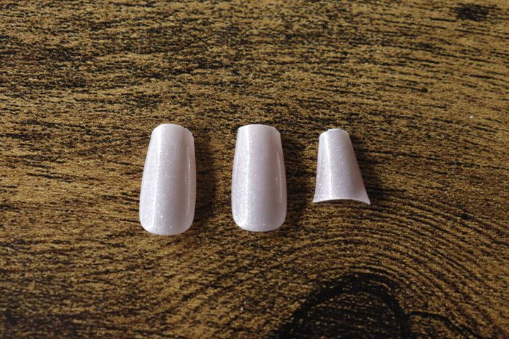 ラウンド、スクエア、ウェルカットに整えられたネイルチップ3つ