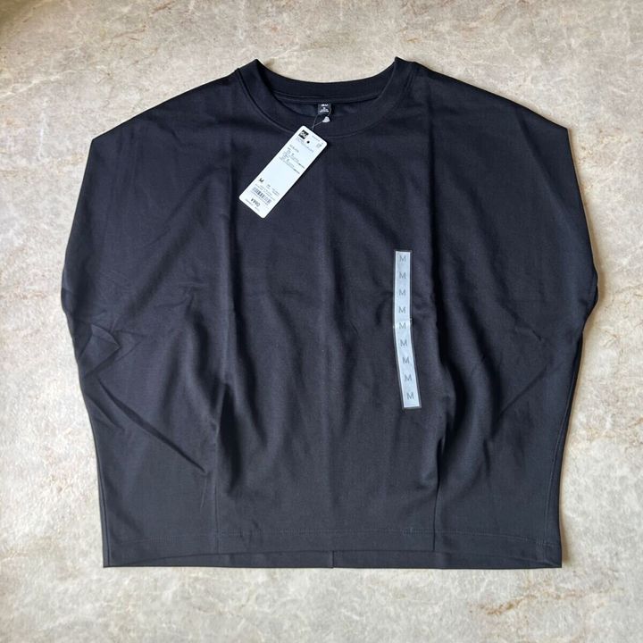 黒いGUドライウエストタックTシャツが平置きされ、タグが付いている