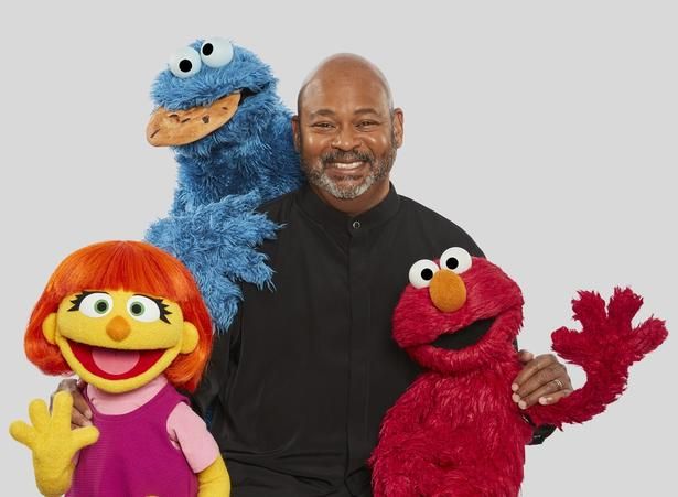 セサミの仲間たちに囲まれる、ルイス・ヘンリー・ミッチェルさん。左手前が、自閉症のキャラクター「ジュリア」