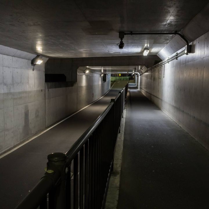 手すりで仕切られた、コンクリート造りの地下通路