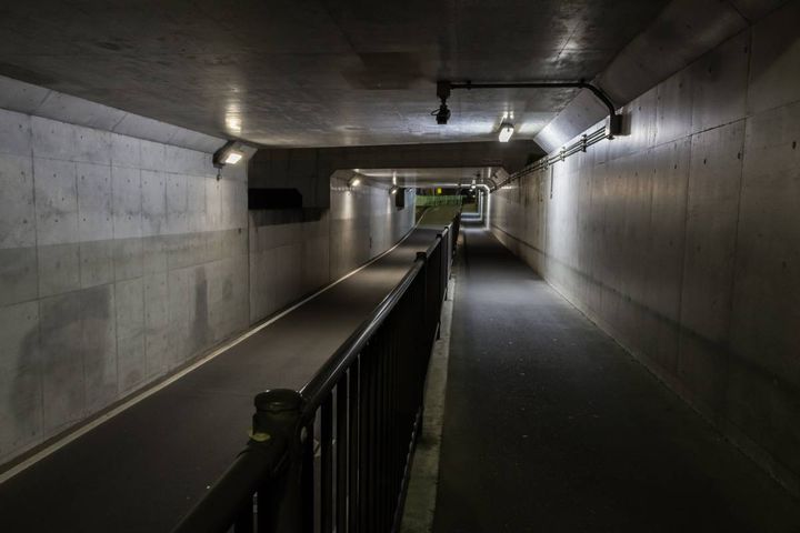 手すりで仕切られた、コンクリート造りの地下通路