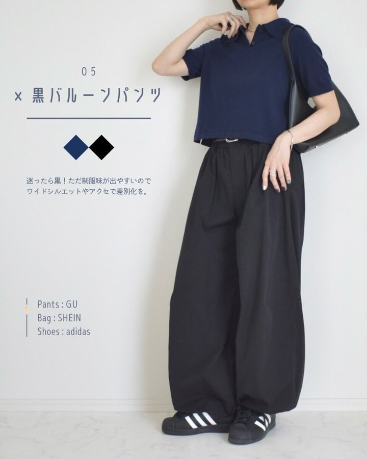 ネイビーのニットポロシャツと黒いバルーンパンツ、スニーカーを着用した女性の全身