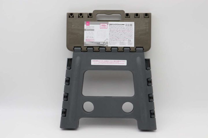 折りたたんだ状態のダイソー折りたたみイス。商品情報シールが見える