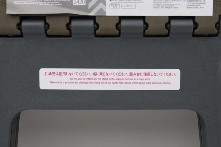 折りたたみイスの注意書きシールのアップ。「乳幼児は使用できない」など