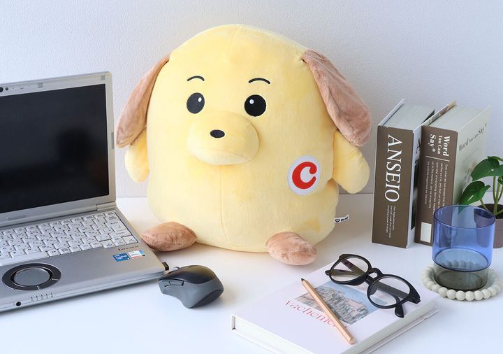 デスクに置かれたカスタム君のぬいぐるみとノートPC