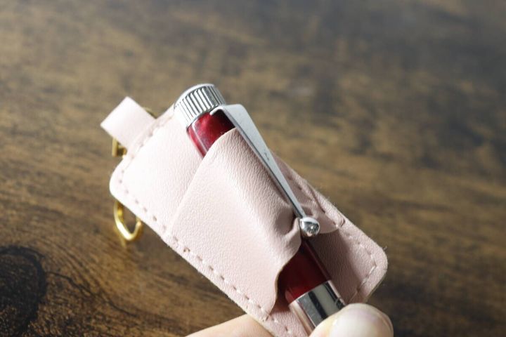 赤いペンをピンクのペンホルダーに差し込んでいる