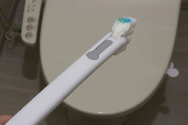 トイレを背景に、洗剤付きブラシが装着されたクリーナーハンドル
