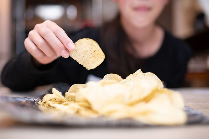 ポテトチップスを握る子供の手