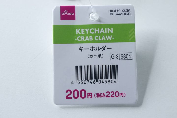 ダイソーのカニ爪キーホルダーの商品タグのアップ。価格とJANコードが見える